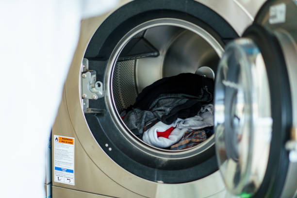 istock Man washing clothes at self-service washing machine store. 1495410744