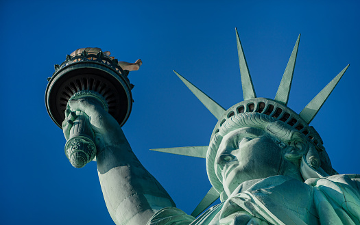 Statue of Liberty in a blue summer sky. Landmark of New York\nBlue sky background with copy space