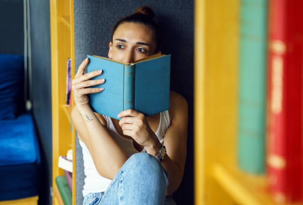 istock Woman reading book at home 1495414528