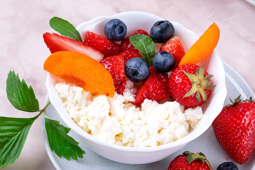 Cottage cheese with strawberry, blueberry and apricot in a bowl. Healthy breakfast