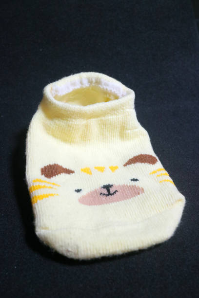 istock Cute baby socks yellow with a hamster face on them 1495414846