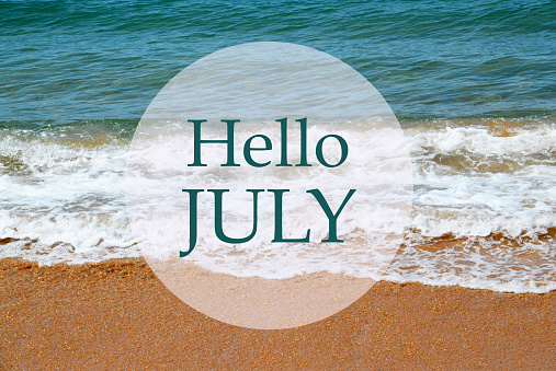 Hello July greeting card with text with on blue ocean water and sandy beach background.Summer vacation,relax or travel concept.Selective focus.