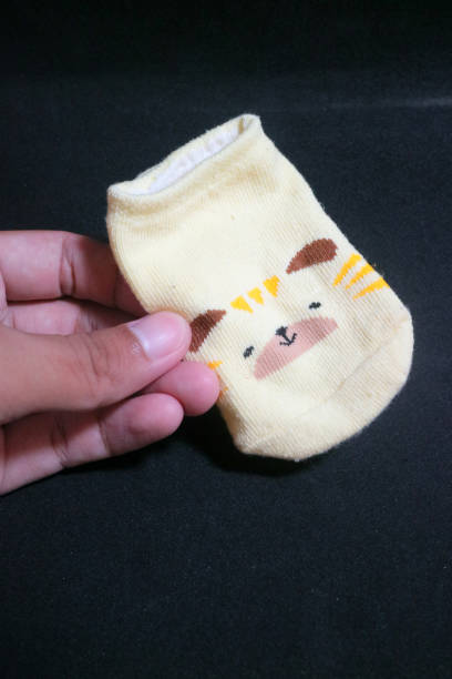istock Cute baby socks yellow with a hamster face on them 1495414997