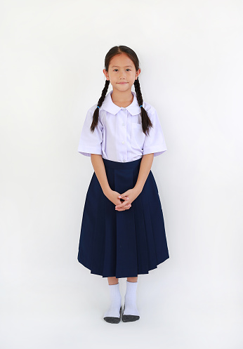 Beautiful Asian little girl child in thai school uniform standing isolated on white background. Full length