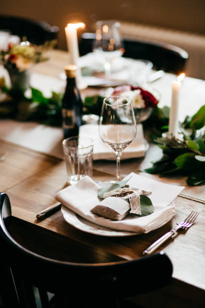 istock Elegant dinner table served for special occasion. Table served with glasses, plate, drinks, forks and knives, burning candles. Served festive table ready for guests. Luxury wedding table 1495416559