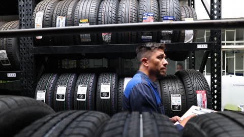 Hombre latinoamericano haciendo un inventario de existencias trabajando en una fábrica de neumáticos