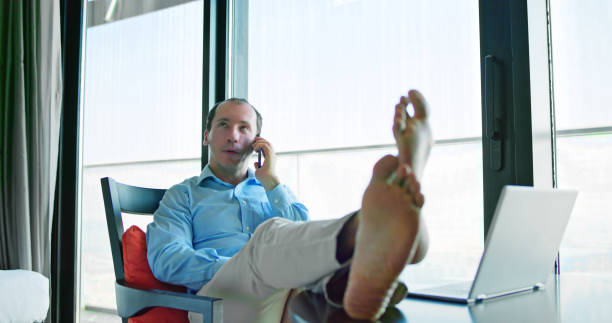 Relaxed Young Businessman Sitting Feet Up At Office Desk