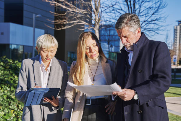 istock Three businesspeople immersed in an intense working session as they meticulously examine a detailed business plan to chart a path towards success. 1495421941