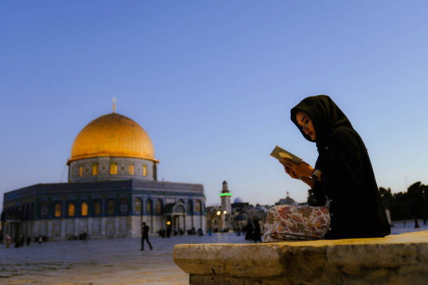 asiatische muslimische frau, die al koran liest, mit felsendom im hintergrund - dome of the rock jerusalem israel arch stock-fotos und bilder