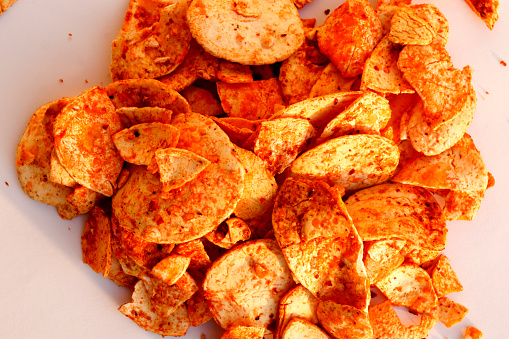 Homemade Spicy Potato Chips Table Top View Isolated on plain white Background.