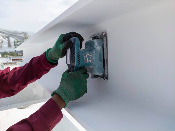istock Using a Ponceuse Vibrante or Orbital Sander to scrub surface intermediate fire proof paint before painting top coat. 1495423588