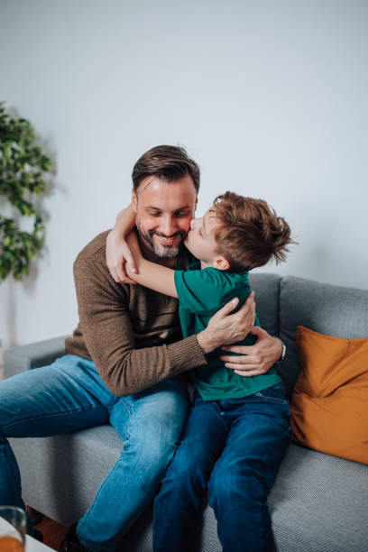 istock Father and Son Embrace on the Sofa, Sharing a Special Connection 1495423625