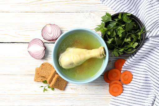 Concept of tasty food with chicken soup on white wooden table