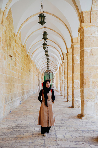 asian muslim woman walking at al-aqsa corridor