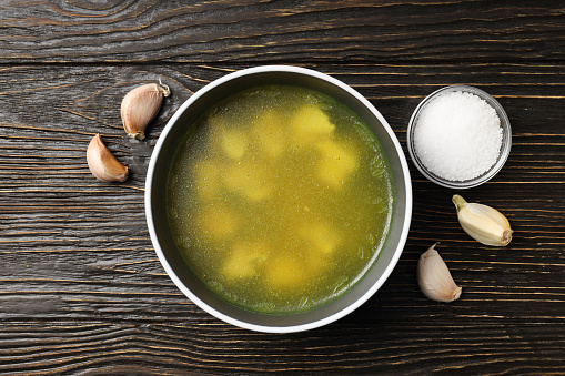 Concept of tasty food with chicken soup or broth on wooden background