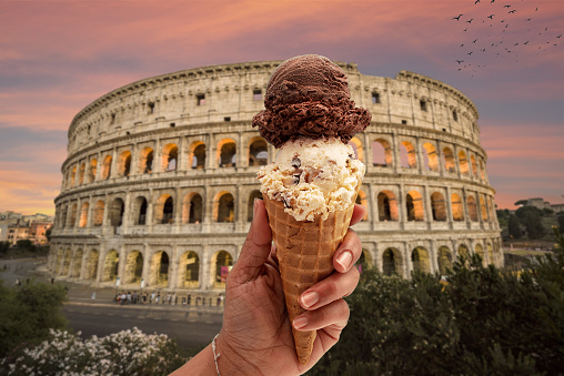 Colosseum at sunset in Rome, Tourist with italian ice cream gelato in hands.