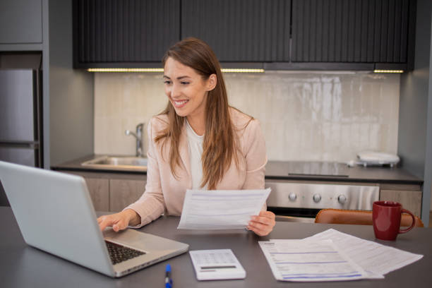 istock Young woman using calculator while going through bills and home finances 1495429648
