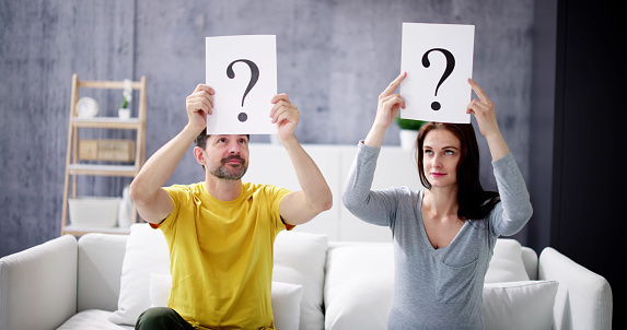 Couple In The Living Room With Question Marks