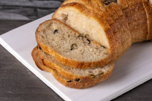 istock Bread with olives on a white cutting board on a gray table 1495435156