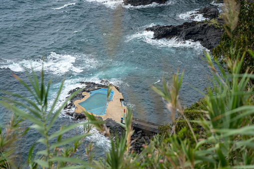 High angle view on volcanic coast and natural swimming pool with hot water in the sea. Sao Miguel, Azores