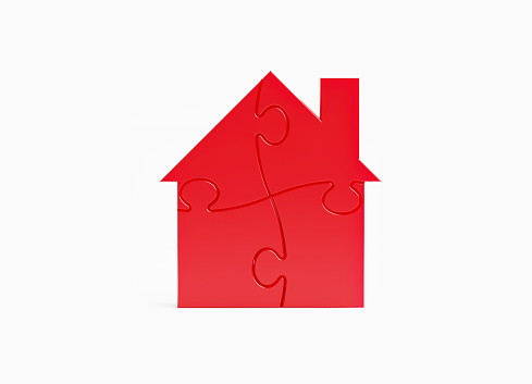 Jigsaw puzzle pieces forming a house shape on white background. Horizontal composition with copy space.
