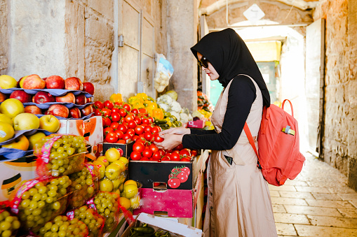 asian muslim woman buying fruit at street market in old city of Jerusalem