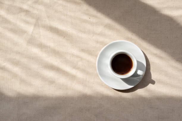 istock Minimalist neutral aesthetic background, coffee cup on beige linen backdrop with abstract natural sunlight shadows, good morning concept, copy space 1495445979