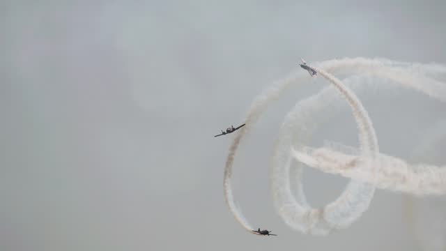 Wonderful stunts are performed by pilots at an air show. They draw a spiral in the sky with their smoke trail