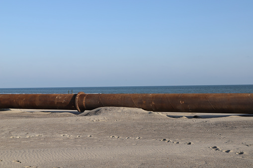 a steel pipe on the beach for conveying sand