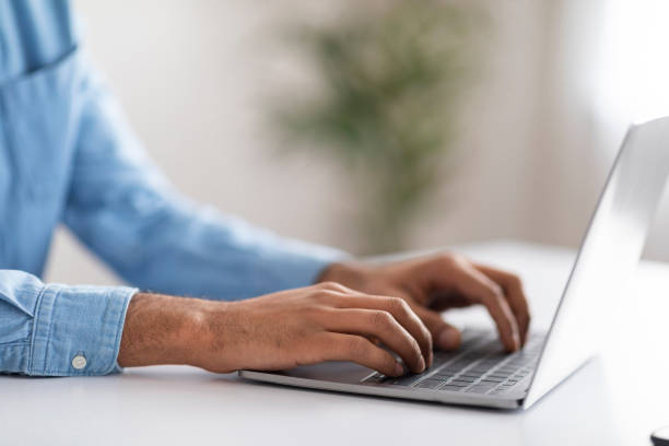 istock Unrecognizable Male Working With Laptop At Desk In Office 1495450779