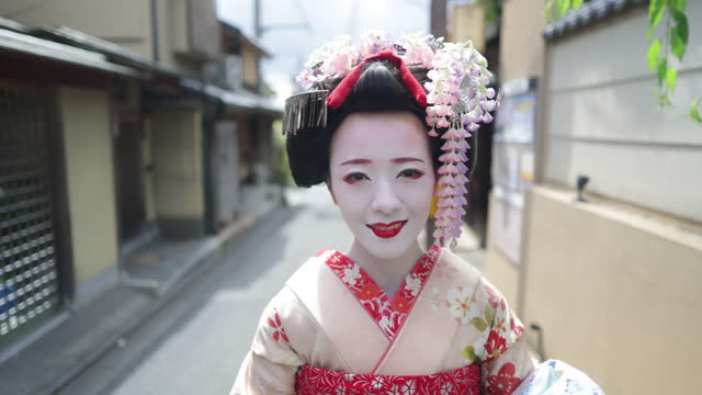 Japanese Maiko (Geisha in training) walking on street and live streaming in Gion, Kyoto