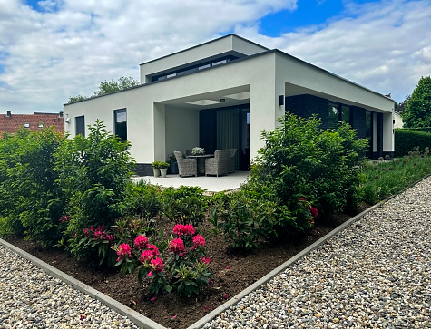 Terborg, Netherlands,  June 02, 2023:  Gravel pathway and rhododendrons in flowerbed