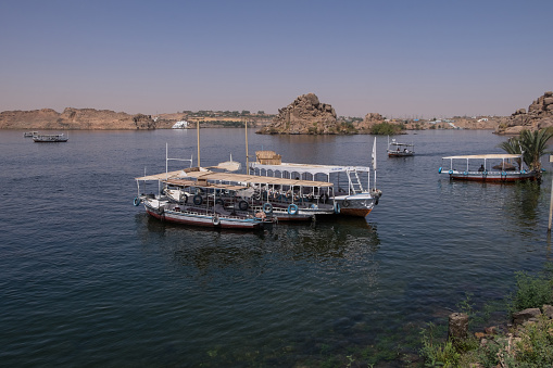Aswan, Egypt - April 28, 2023: Boats in the waters of the Nile at the Aswan Dam