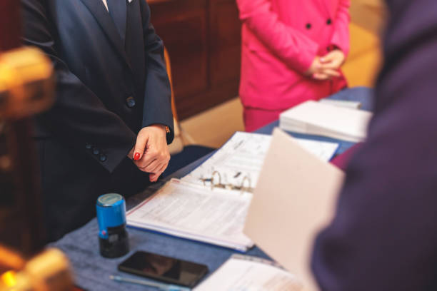 istock Registration desk table, process of checking in on a conference congress forum event, visitors and attendees receiving a name badge and entrance wristband bracelet and register electronic ticket 1495478900