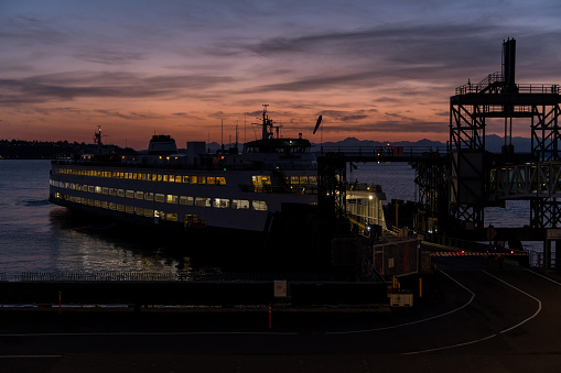 Seattle, USA - Mar 16, 2023: Elliott Bay late in the day as a Ferry disembarks and embarks commuters the Colman dock at Sunset.