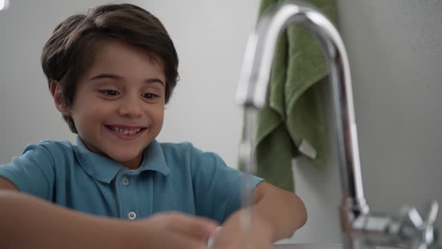 Boy washing his hands in the bathroom at home