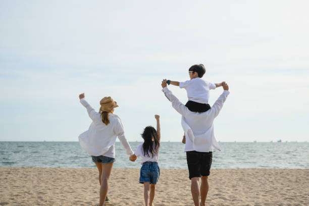istock Happy family spending vacation time together on beach 1495498335
