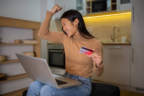 istock Woman using her credit card to shop online 1495500694