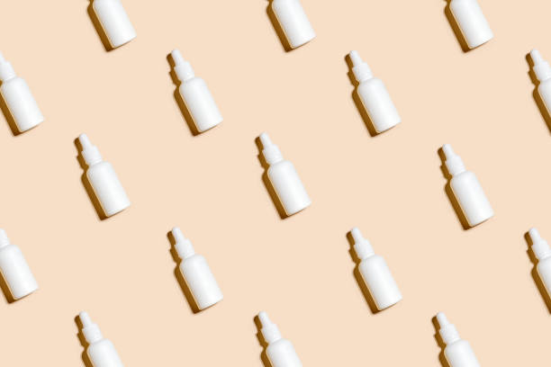 istock Pattern of anti aging serum in white bottle with dropper on pastel beigh background. Creative layout, cosmetic seamless pattern, flat lay. For packaging design, printing on fabric, paper 1495501912