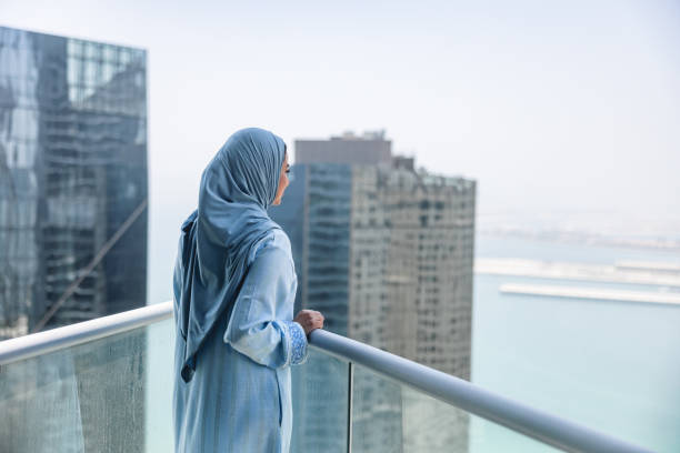 зрелые женщины ближнего востока наслаждаются видом на дубай с балкона - women middle eastern ethnicity islam hijab стоковые фото и изображения