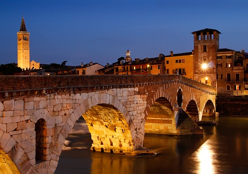 An evening view of the Ponte Pietra (Stone Bridge) across the river Adige in Verona Italy