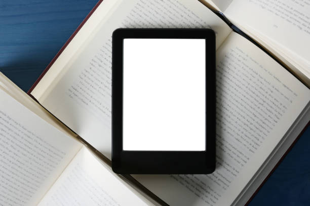 istock Portable e-book reader and hardcover books on blue wooden table, flat lay 1495506459