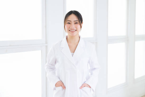 attractive asian woman in a white coat stock photo