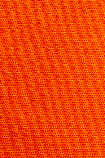 Orange color sports clothing fabric football shirt jersey texture and textile background.