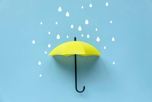 istock Yellow umbrella and rain drop over a blue background. 1495516785