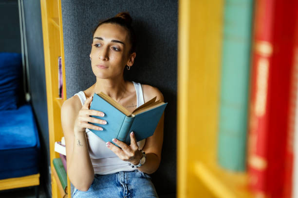 istock Woman reading book at home 1495522182