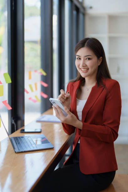 istock Consultant, advisor, Asian business woman working on the computer and using smartphone mobile talking work financial and marketing business planning company profits, marketing planning budget. 1495528634