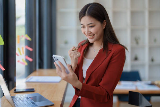 istock Excited businesswoman using mobile phone while in office , business concepts. 1495528660