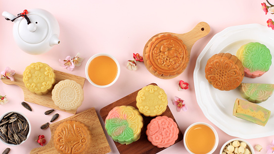 Mid Autumn Festival Food and Drink on Pink Background. Variety of Mooncake and Seeds.