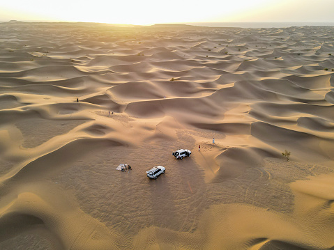 The drone point of view of two SUVs in the vast desert area